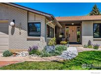 Charming brick home featuring a landscaped walkway and stylish wooden front door, enhancing curb appeal at 505 Lois Dr, Louisville, CO 80027
