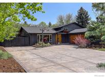 Contemporary home featuring a large driveway, charcoal exterior and complementary landscaping at 6862 Roaring Fork Trl, Boulder, CO 80301