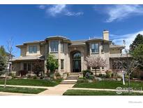 Elegant two-story home with a brick facade, arched entryway, manicured lawn, and beautiful landscaping at 725 E Wiggins St, Superior, CO 80027