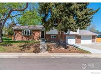 Charming brick home with well-maintained landscaping and a mature tree in the front yard at 10547 Lipan St, Northglenn, CO 80234