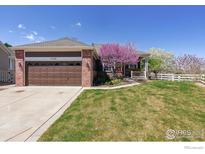 Charming single Gathering home featuring an attached garage, well manicured lawn, and mature trees at 13668 Plaster Cir, Broomfield, CO 80023