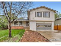 Charming two-story home with a manicured lawn, mature tree, and attached garage at 1506 Fisk Ct, Longmont, CO 80503