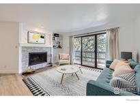 Living room featuring a fireplace, shelving, new vinyl flooring, and balcony access at 3363 Oneal Pkwy # 36, Boulder, CO 80301