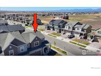 A high angle aerial view of a brown two story townhome in a neighborhood with mountain views at 700 Lillibrook Pl, Erie, CO 80026