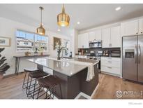 Bright kitchen features a large island, stainless steel appliances, and modern cabinetry at 700 Lillibrook Pl, Erie, CO 80026