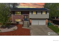 Charming split-level home featuring solar panels, a manicured yard, and a two-car garage at 8351 Ralph Ln, Denver, CO 80221