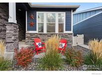 Charming home featuring a cozy front porch with red Adirondack chairs at 8938 Ferncrest St, Longmont, CO 80504