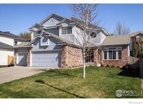 Charming two-story home features a blue exterior, brick accents, and a well-maintained lawn at 1009 Monarch Way, Superior, CO 80027