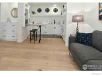 Bright kitchen features new light wood floors, white cabinetry, and a cozy breakfast bar at 1089 Laramie Blvd, Boulder, CO 80304