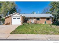 Charming brick home featuring a well-maintained lawn and attached garage at 111 Barbara St, Louisville, CO 80027