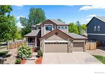 Charming two-story home featuring a three-car garage, landscaped yard, and inviting front porch at 1500 Red Mountain Dr, Longmont, CO 80504