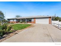 Charming single-story home with a well-maintained lawn and an attached two-car garage at 16160 Yosemite St, Brighton, CO 80602
