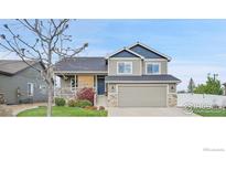 Charming two-story home featuring a welcoming front porch and manicured lawn at 1725 Exeter St, Berthoud, CO 80513