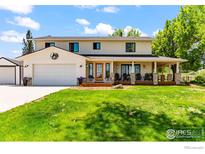 Charming two-story home with a large front yard, covered porch, and a two-car garage at 2017 Vaquero St, Longmont, CO 80504