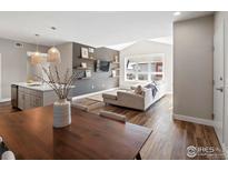 Open-concept living area featuring modern furnishings and dark-stained hardwood flooring throughout at 210 S Cherrywood Dr # 303, Lafayette, CO 80026