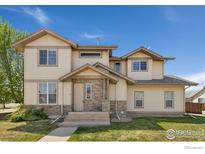 Two-story home showcasing a blend of siding and stone accents under a bright blue sky at 2104 18Th Ave, Longmont, CO 80501