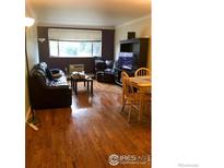 Inviting living room featuring hardwood floors, a comfortable leather sofa and a dining area perfect for entertaining at 2295 E Asbury Ave # 206, Denver, CO 80210