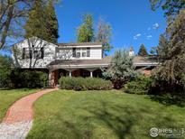 Charming home featuring a well-manicured front lawn, brick walkway, and a cozy covered porch at 2434 S Kirkwood Ct, Denver, CO 80222
