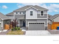 Two-story home with a gray exterior, large two-car garage, and a well-maintained front yard at 270 Sabin Way, Lochbuie, CO 80603