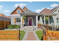 Charming home with a red door, stone walkway, wood fence, and manicured front yard at 3207 N Marion St, Denver, CO 80205
