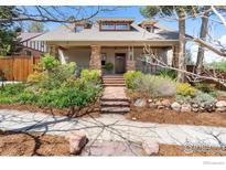 Charming home featuring a landscaped front yard with stone accents and inviting covered porch at 721 9Th St, Boulder, CO 80302