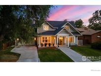 Charming two-story home features a landscaped front yard, covered porch, and inviting curb appeal against a colorful twilight sky at 724 Johnson St, Louisville, CO 80027