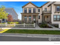 Charming two-story home with a welcoming porch and a well-maintained front yard with picket fence at 97 Westerly Blvd, Erie, CO 80516