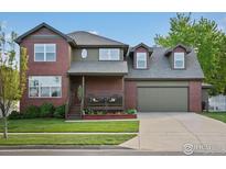Charming two-story brick home featuring an attached two-car garage and a covered porch at 1141 Jefferson Dr, Berthoud, CO 80513
