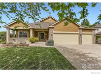 Charming single-Gathering home with a manicured lawn, covered porch, and three car garage at 11731 Center Dr, Longmont, CO 80504