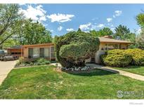 Charming single-story home with mature landscaping, green lawn, and inviting curb appeal at 1235 Lincoln St, Longmont, CO 80501