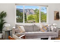 Inviting living room features a comfortable couch and scenic mountain views through a large window at 1350 Lehigh St, Boulder, CO 80305