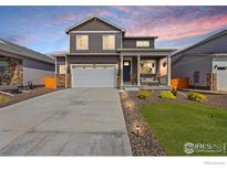 Charming two-story home with a well-manicured lawn, stone accents and a welcoming front porch at 14640 Guernsey Dr, Mead, CO 80542