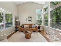 Bright living room with a large window, vaulted ceiling and modern decor at 180 Mercator Ave, Lafayette, CO 80026