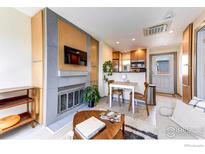 Cozy living room features a stone fireplace, dining table, and an open concept to the kitchen area at 3025 Broadway St # 10, Boulder, CO 80304