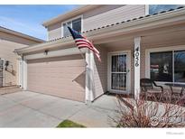 Charming front exterior of home featuring an American flag, porch and two car garage at 4056 Perth St, Denver, CO 80249