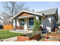 Charming home featuring a welcoming front porch, lush garden beds, and a well-maintained lawn at 4401 Vrain St, Denver, CO 80212