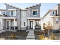Charming townhouse featuring a modern facade with stone accents and a cozy front porch seating area at 47 N Uriah St, Aurora, CO 80018