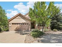 Charming home featuring a stone and siding exterior, a two-car garage, and beautifully landscaped front yard at 6542 S Tempe St, Aurora, CO 80016