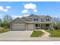 Charming two-story home boasts a three-car garage, manicured lawn, and inviting stone walkway at 708 Teal Cir, Longmont, CO 80503