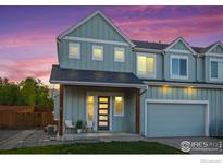Charming home featuring a covered porch, modern door, and two-car garage against a colorful sky at 919 Russell St, Golden, CO 80401