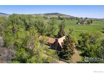 Idyllic aerial view of a charming brick home surrounded by lush greenery and a well-manicured lawn at 12855 N 66Th St, Longmont, CO 80503