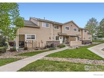 Two-story townhouse with neutral siding, brick accents, and a well-maintained lawn at 1601 Great Western Dr # D3, Longmont, CO 80501