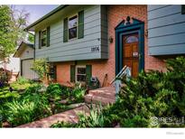 Inviting exterior showcasing a well-manicured front yard and charming brick facade and stylish wooden door at 1805 Del Rosa Ct, Boulder, CO 80304