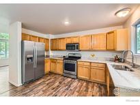 Bright kitchen features stainless steel appliances, wood cabinets, and marble countertops at 1842 Reliance Cir, Superior, CO 80027