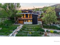 Modern home with a two-story design, dark siding, and a balcony overlooking a landscaped front yard at 2725 6Th St, Boulder, CO 80304