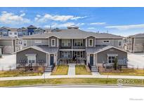 Stylish townhome featuring gray siding, stone accents, fenced yards, and well-maintained landscaping at 350 High Point Dr # 201, Longmont, CO 80504