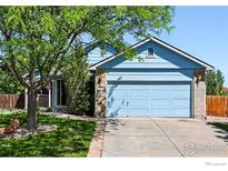 Charming single-Gathering home with a blue exterior, brick accents, well-maintained lawn, and mature trees at 3715 E 139Th Pl, Thornton, CO 80602