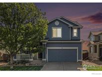 Charming two-story home with attached garage, lush landscaping, and inviting front porch at 4005 Frederick Cir, Longmont, CO 80503