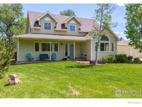 Charming home with a well-manicured lawn, covered porch, and mature trees at 7430 Cardinal Ln, Longmont, CO 80503