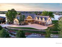 A luxurious home showcasing a beautiful stone exterior with a meticulously landscaped front yard and private pond at 9833 Shoreline Dr, Longmont, CO 80504